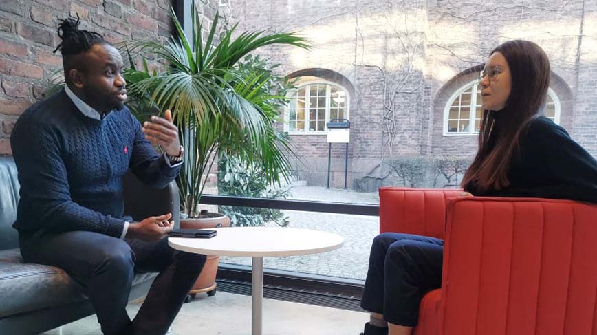 Mentorn Jerry Onyeche och studenten Marina Brandt samtalar i entrén till KTH bibliotek.