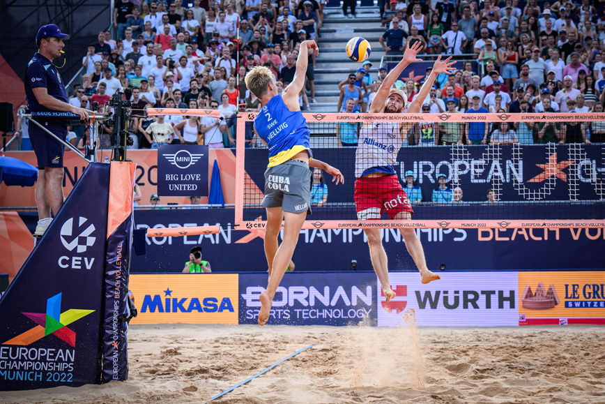 Jonatan Hellvig, fotograferad bakifrån, slår en smash i EM-semifinalen i beachvolleyboll mot Norge.