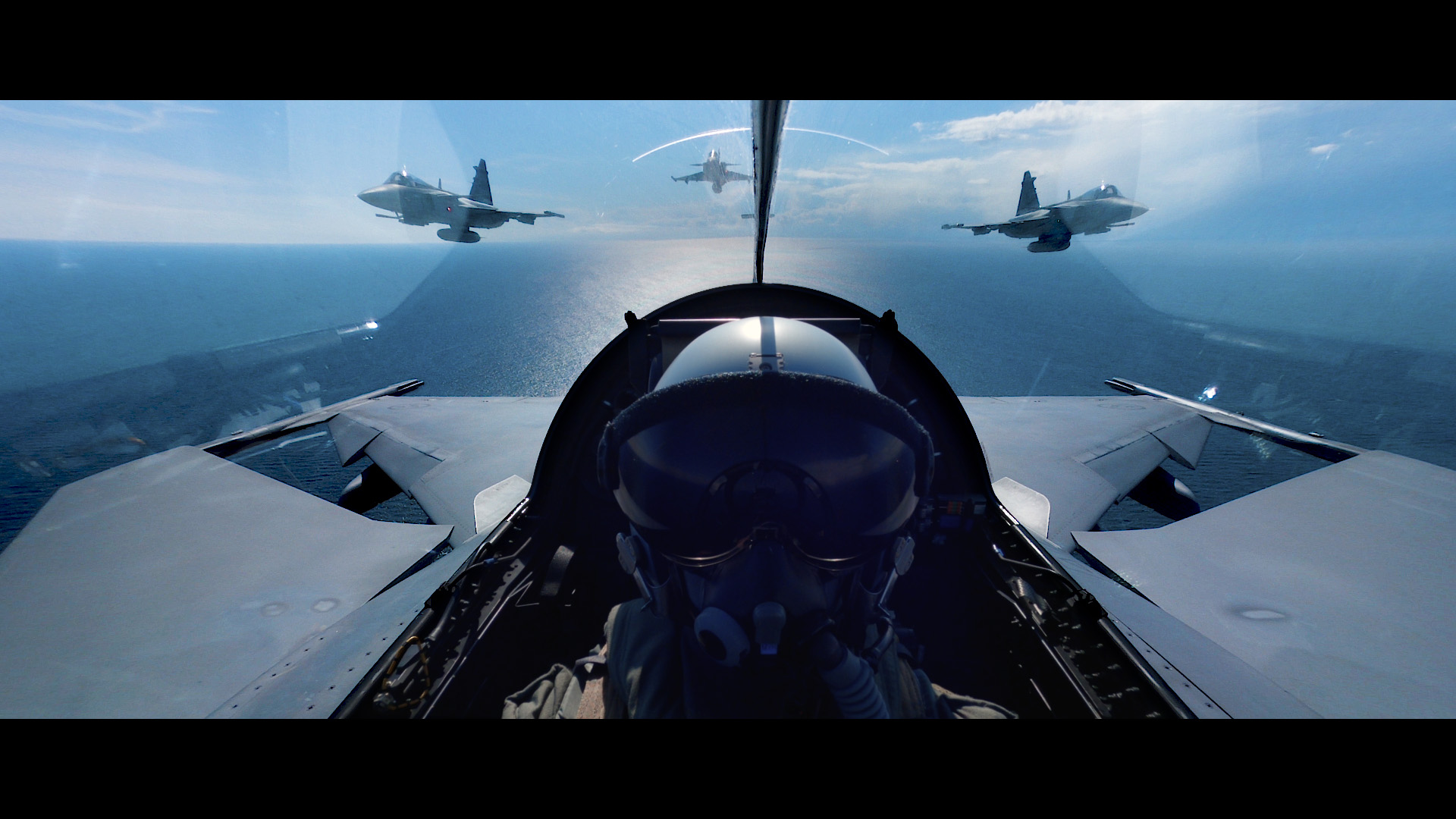 One person in a fighter jet with two other fighter jets flying behind