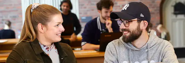 Två studenter ler mot varandra